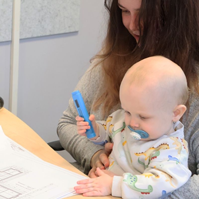 Beth holding baby Archie in the Frame Build UK office as she returns to join the estimating team